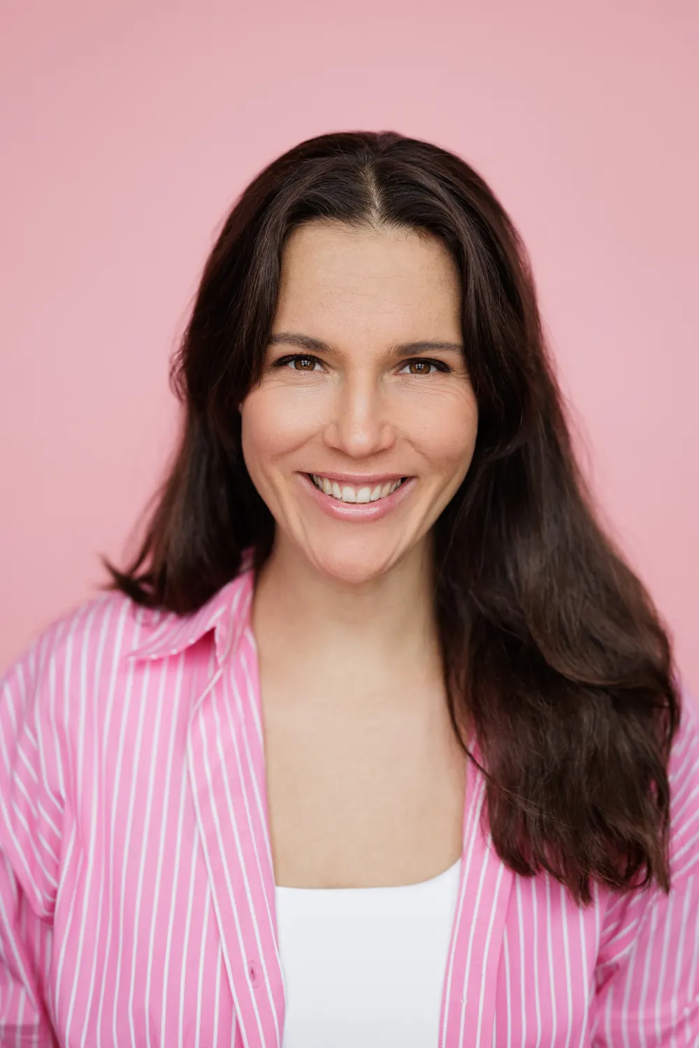 Ira Schiwek smiling in a pink striped blouse